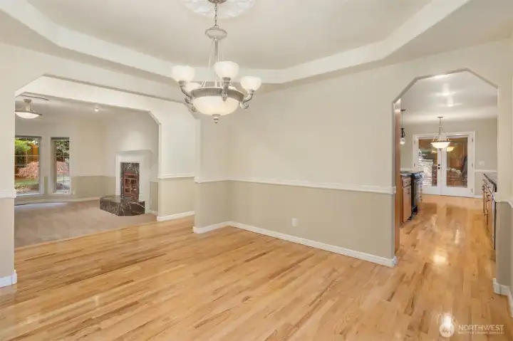 Formal dining room off kitchen with forest views.