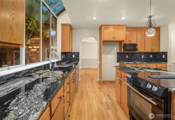 Down draft oven in island, ample counterspace and cabinets for cooking and storage.