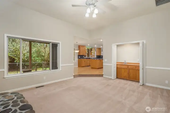 Wet bar and river rock fireplace off kitchen for a cozy connected space to relax and entertain.