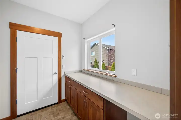 Oversized utility room just off the garage with desk and storage space.