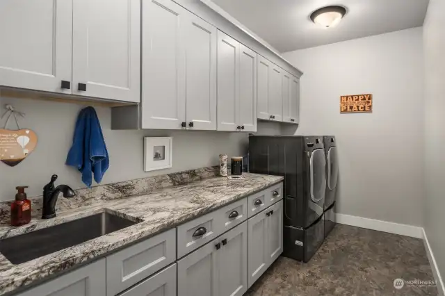 Convenience meets luxury in the expansive laundry room, complete with Wi-Fi enabled washer and dryer and an abundance of custom cabinetry.