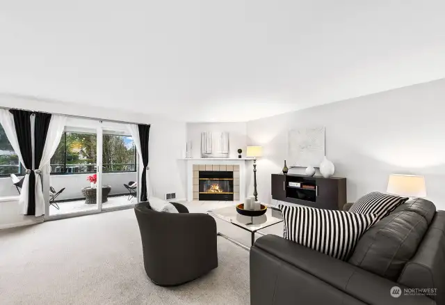 Spacious living room with wool carpet, a wood-burning fireplace, and adjacent covered deck.