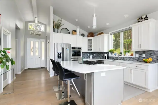 Gourmet kitchen with gas cooktop and quartz counters.