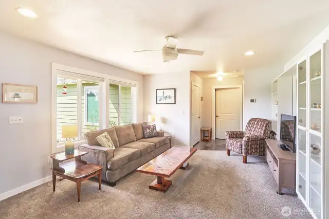 Living room with primary suite, utility room and garage entry ahead