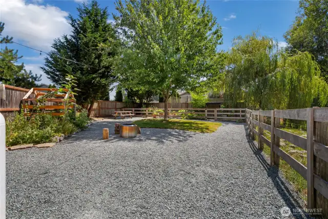Park-like fenced back yard with garden and coop.