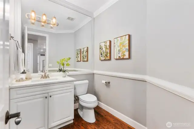 Chic powder room with wainscoting detail, stylish lighting, and a bright vanity-conveniently located on the main level.