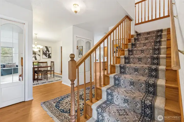 The classic entry with gorgeous, true-hardwood flooring, beautifully milled stair railings and inset carpet with hardwood borders, evokes the classic, custom feel of a traditional home. Two closets with mirrored doors in entry too.
