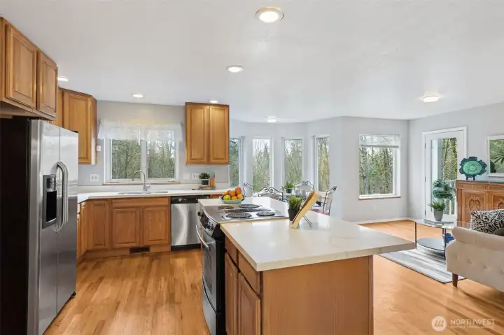 A stainless appliance package highlights the kitchen with ceiling height cabinetry, cabinet pull outs and a lovely kitchen sink view, all crowned by marble style countertops.
