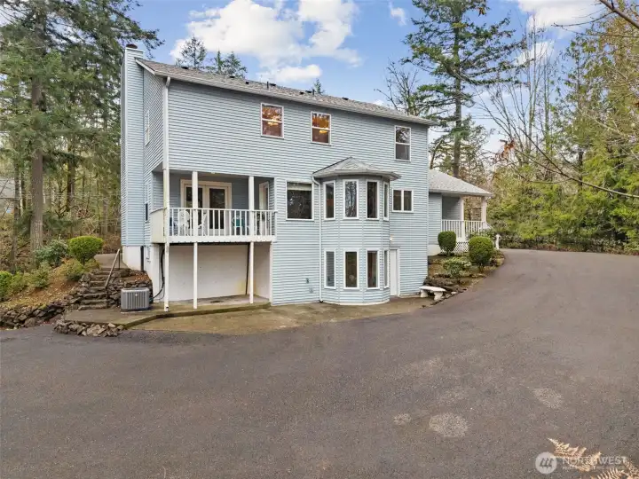 A rear view of the home shows the lower level private entrance from the parking area. The full daylight, basement level can be accessed easily, with plenty of parking, to create a private living space in the home.