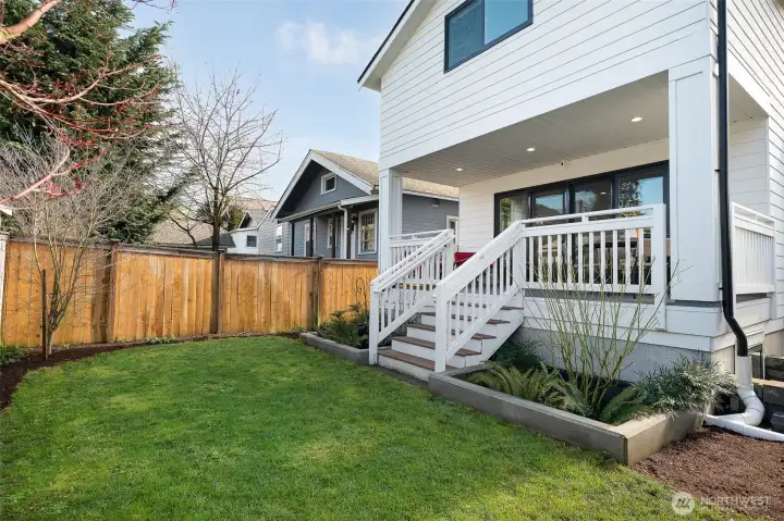 Inviting back deck leads to fenced backyard
