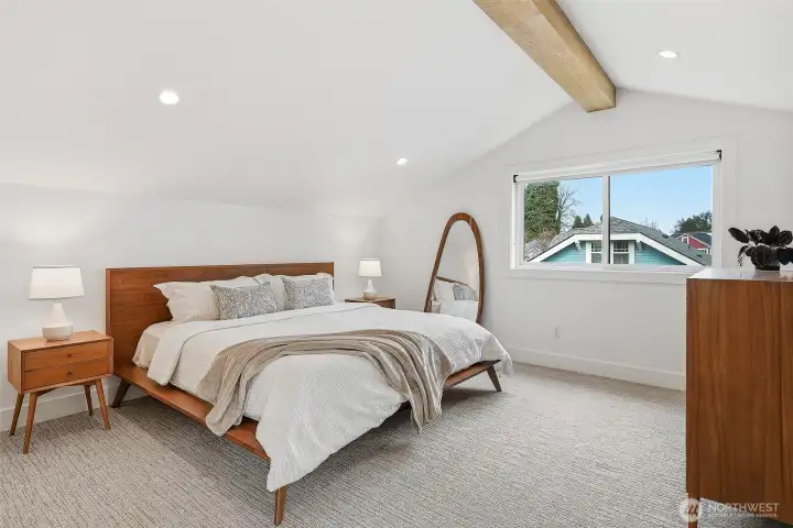 Spacious primary suite with exposed beam detailing