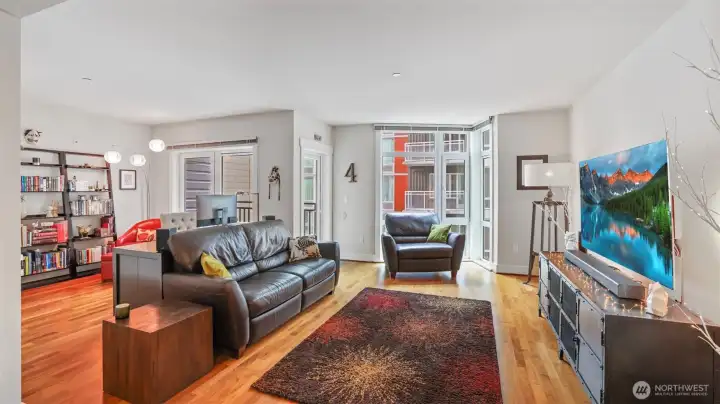Living room with floor to ceiling windows, refinished walnut floors.