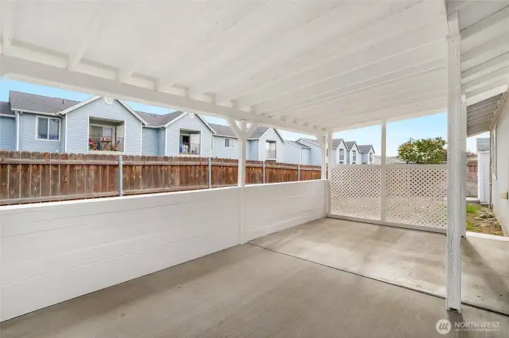 This covered back patio is one of our favorite things about this home. It has fresh paint and brand new lattice to protect you from the sun and wind, and adds a little bit of extra privacy for you.