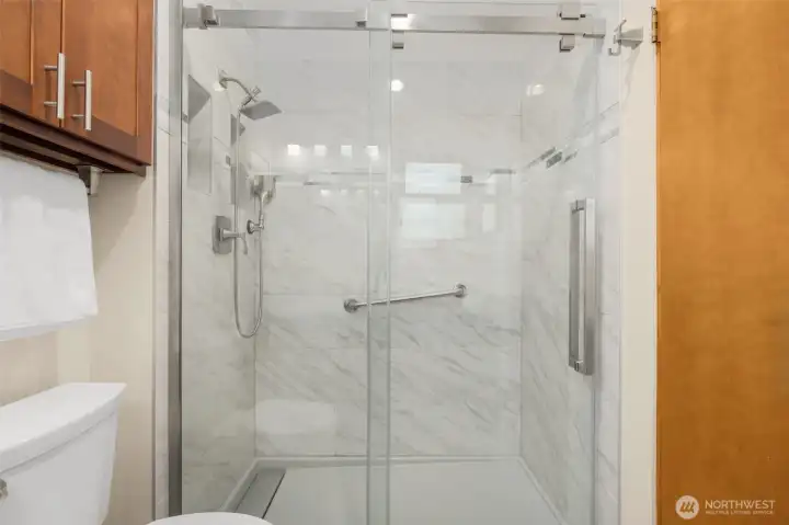 Primary suite bathroom with updated glass shower doors