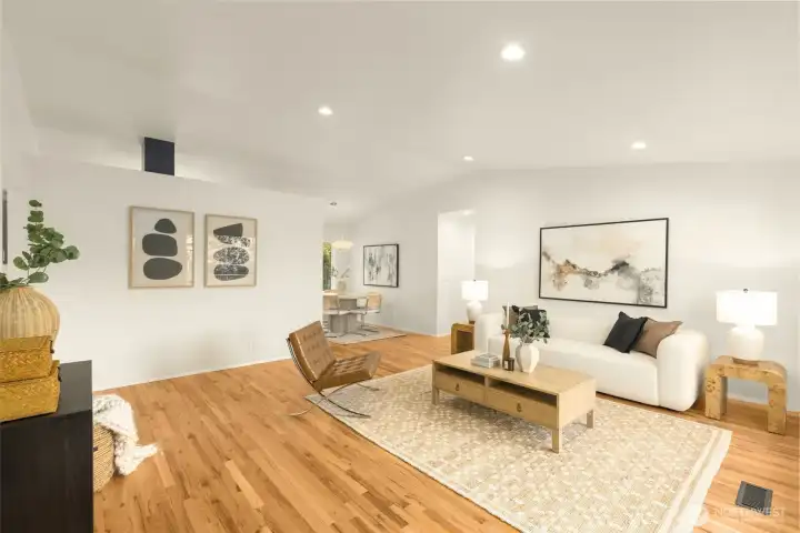 Inviting living room with vaulted ceilings, canned lights, and refinished hardwood floors.