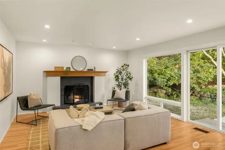 The inviting family room features a wood-burning fireplace, dramatic floor-to-ceiling windows, and seamless patio access for indoor-outdoor living. Family room flows effortlessly into the kitchen and backyard.
