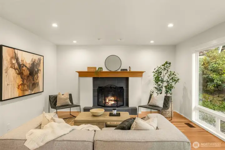 The inviting family room features a wood-burning fireplace, dramatic floor-to-ceiling windows, and seamless patio access for indoor-outdoor living. Family room flows effortlessly into the kitchen and backyard.