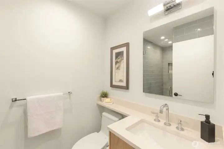 Ensuite with designer tile shower and sleek modern vanity.