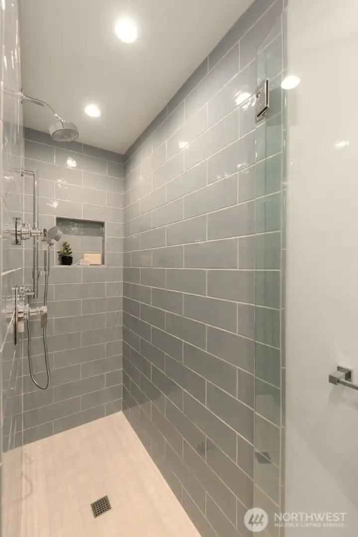 Ensuite with designer tile shower and sleek modern vanity.