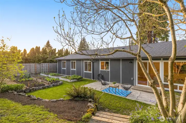 Outdoors, the gardener’s paradise offers mature raised beds brimming with vegetables and greens, an adorable playhouse or potting shed, and composter.