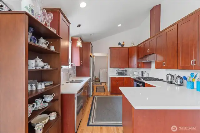 Kitchen with quartz counters, wood cabinets, gas range