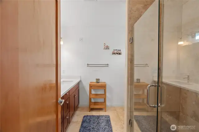 Primary ensuite bath with walk-in shower, double sinks, heated tile flooring