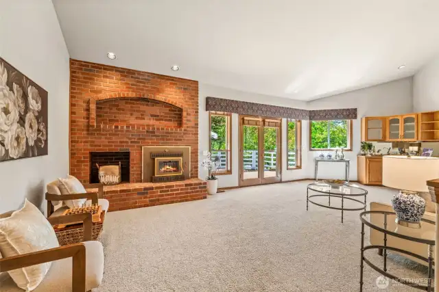 Large family room, overlooking rear deck via French doors, is oversized, with 1 of 3 fireplaces in the home, this a wood-burning insert.