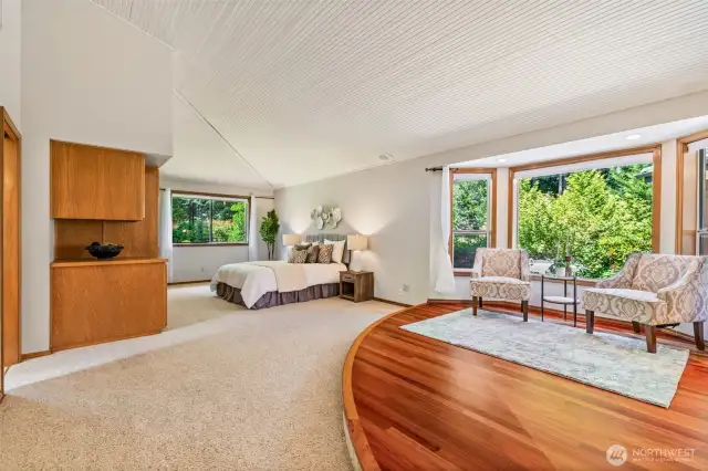 Oversized primary bedroom with valuted ceiling easily accommodates king-size suite of furniture.  Built in cabinetry idea for storage.