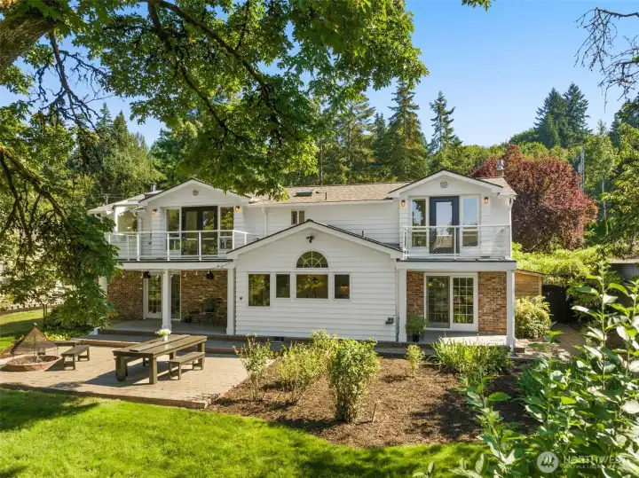 Welcome to this beautifully remodeled home, where timeless design blends seamlessly with modern comforts and a lush green backdrop.