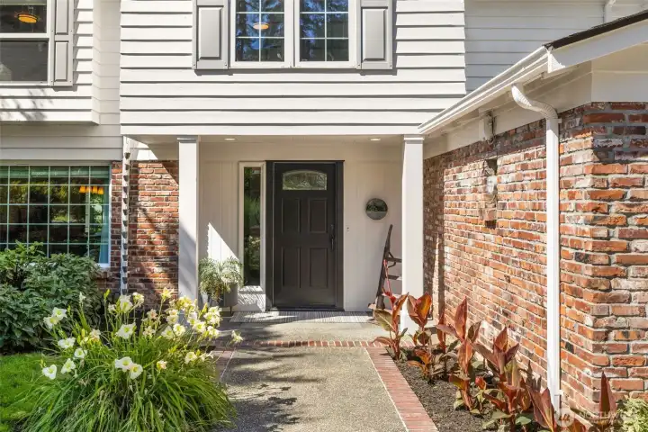Charming entry with brick detailing and fresh landscaping sets the tone for a warm welcome.