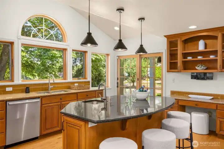 A chef’s kitchen designed for entertaining, complete with custom wood cabinetry, stone counters, and an inviting island with seating.