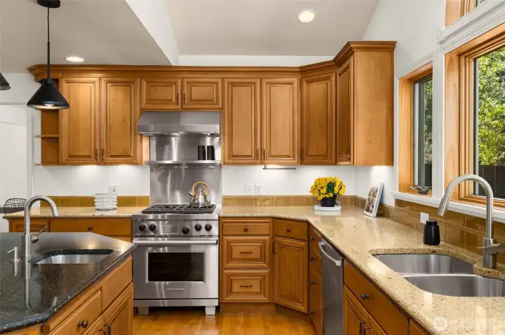 Rich wood finishes and oversized windows create a warm, open flow through this gourmet kitchen.