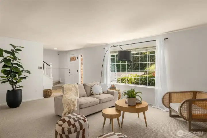 An inviting living room with picture windows allows sunlight to pour in and highlight the spacious interiors.
