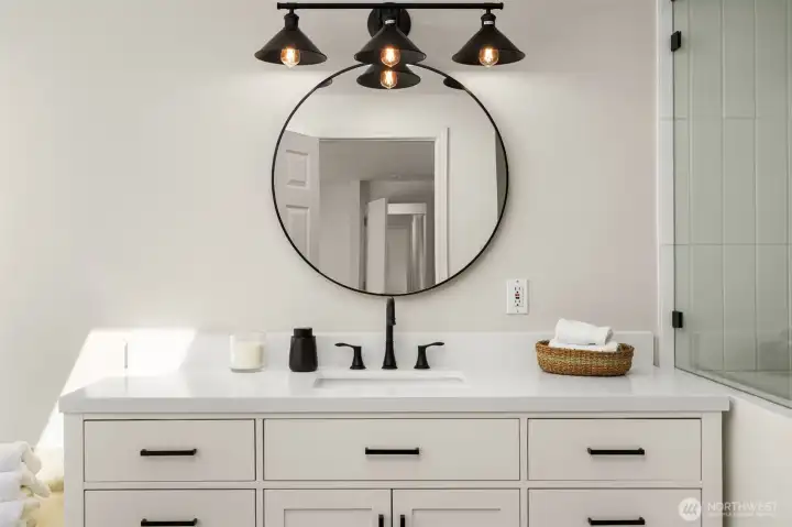 The spa-like bathroom features double vanities, chic lighting, and elegant finishes. Every detail is designed to elevate daily routines into moments of luxury.
