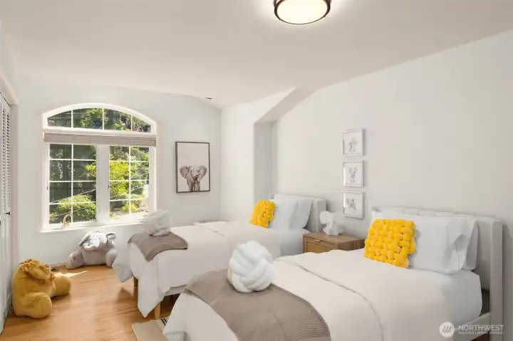 This secondary bedroom is filled with light and charm. Flexible in design, it can serve as a guest room, nursery, or creative space.