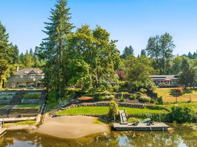 The open lawn is framed by evergreens, offering space for play, gardens, or outdoor entertaining. It’s a natural extension of the home’s indoor living.