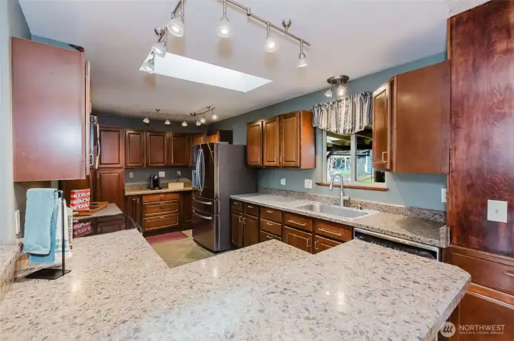 Spacious kitchen with breakfast bar seating and ample counter space.