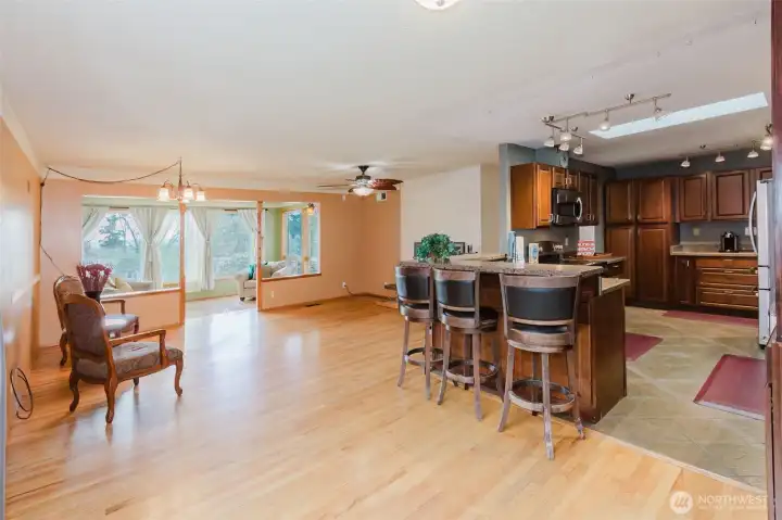Seamless flow between living room and kitchen with breakfast bar.