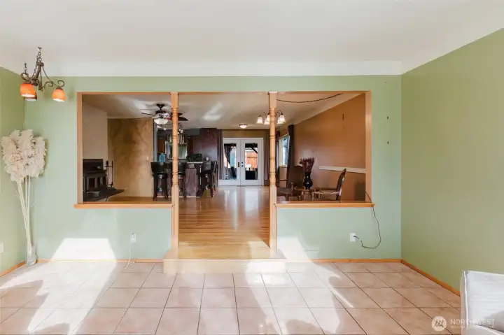 Sunroom open to the main living area with step-up transition to hardwood floors.