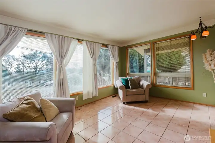 Spacious sunroom with wraparound windows and neighborhood views.