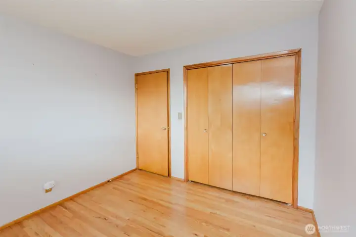 Secondary bedroom with hardwood floors and double closet.