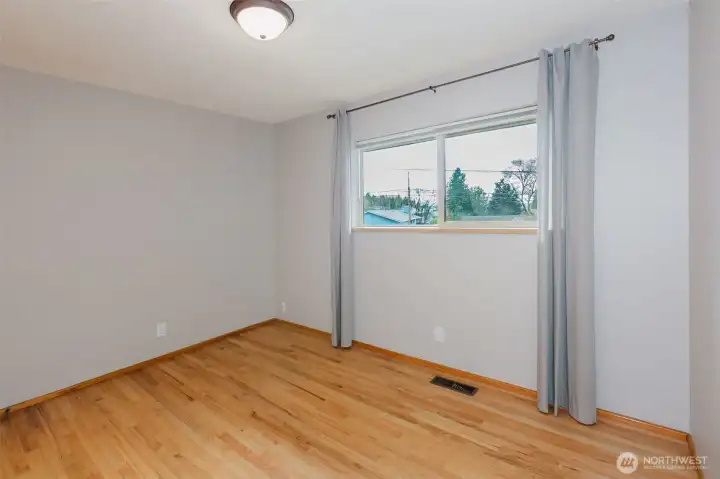 Secondary bedroom with hardwood floors and built-in closet.