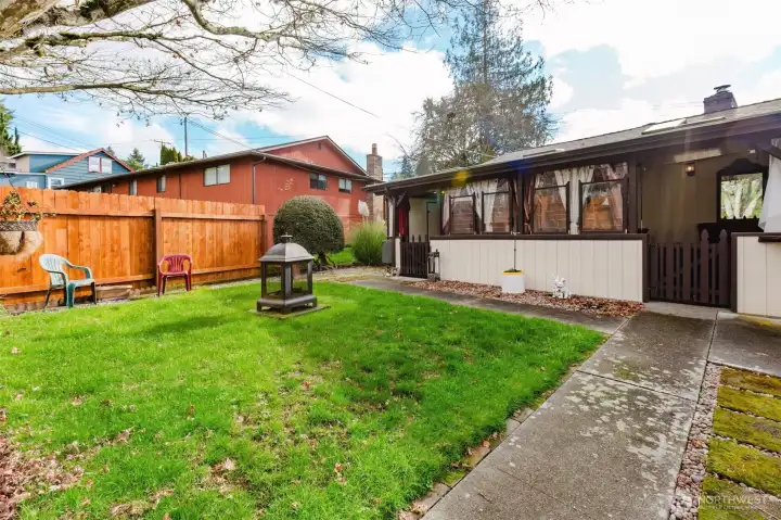 Spacious backyard with mature tree and fenced perimeter.