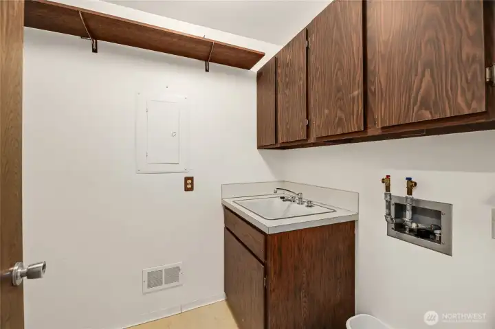 Laundry room with utility sink, storage shelves & upper cabinets