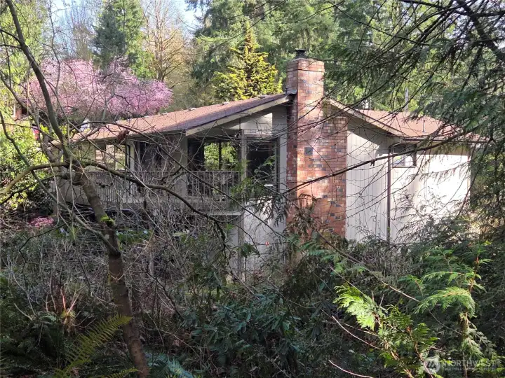 House view from the 2nd driveway. There is a stand up crawl space with access under the deck
