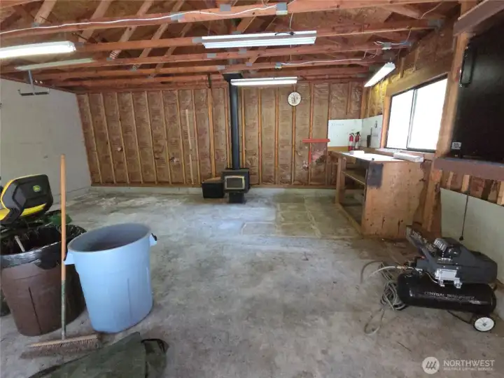 Detached 2 car garage has a work area and wood stove