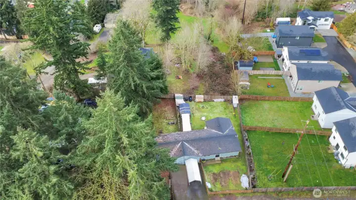 Lot extends beyond fence on right side, see overgrown area, approximately 55x114 for potential upside.