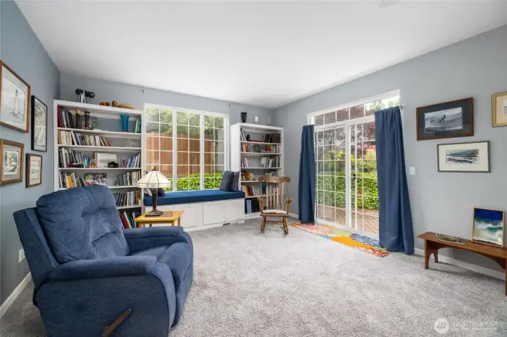 Custom built-in bookcases and a cozy window seat make the ideal space for a good book, or conversation with a friend.  Slider opens to fenced yard and patio.