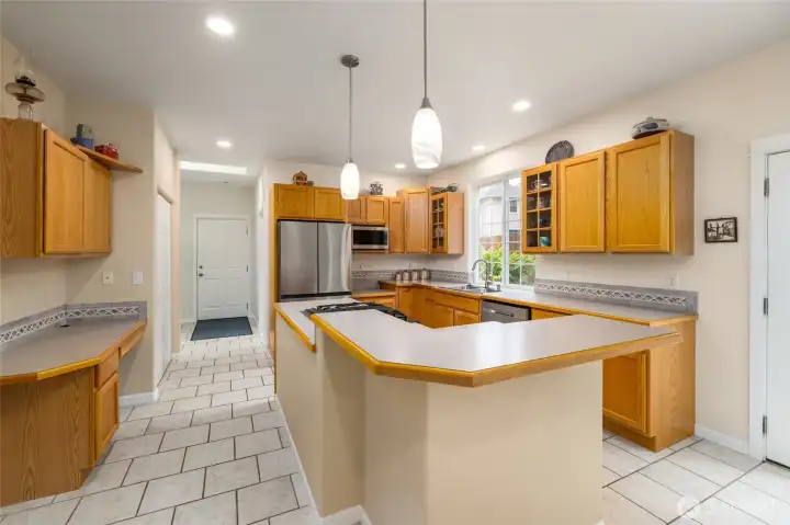 Fantastic kitchen has tons of storage, a large center island, stainless appliances, gas cooktop.  The tile floor starts at the entry from the attached 2 car garage, and runs throughout the mudroom, 1/2 bath, oversized laundry, and kitchen. A built-in desk area offers convenient home organization.