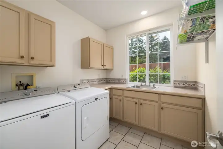 The laundry room of your dreams - so much room, so much storage!  Convenient sink, folding counter, and abundant storage.  Tile floor for easy care and protection from water.